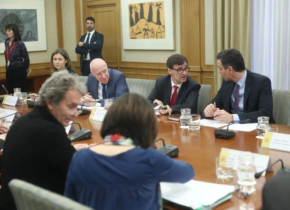 Salvador Illa (3i) habla con Pedro Sánchez (4i), acompañados de Fernando Simón (de espaldas), durante el comité de evaluación y seguimiento del coronavirus