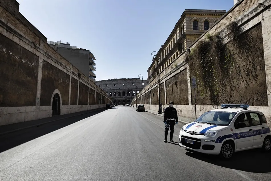 Un policía con mascarilla y el Coliseo al fondo. Foto: EP