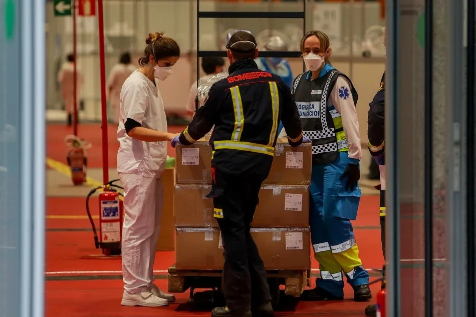 Una enfermera, un bombero y un técnico sanitario conversan en el interior del hospital Temporal de la Comunidad de Madrid en IFEMA para pacientes con Covid-19 | EP