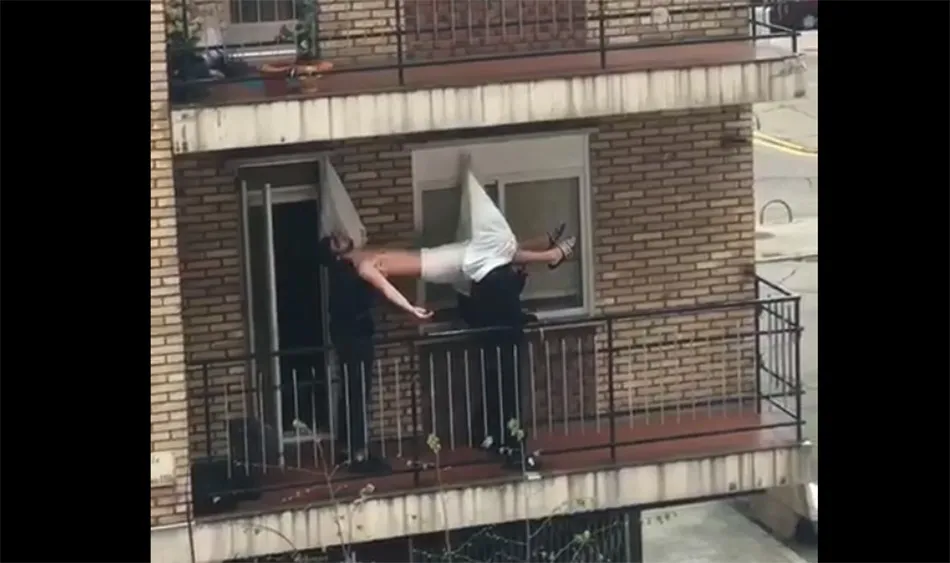 Unos estudiantes procesionan por Semana Santa en su balcón