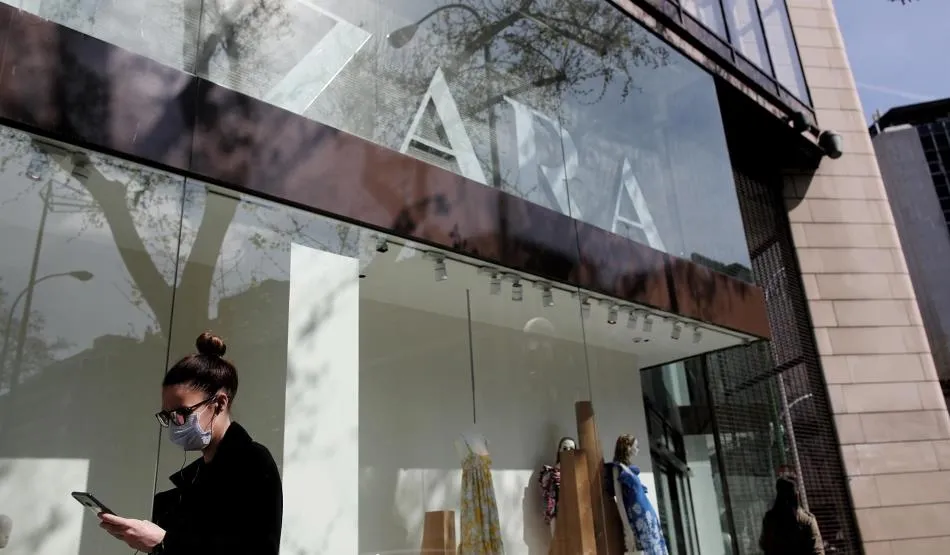 Una mujer con mascarilla pasa junto al escaparate de la tienda Zara de la Calle Princesa de Madrid del grupo Inditex. Foto de Eduardo Parra - EP