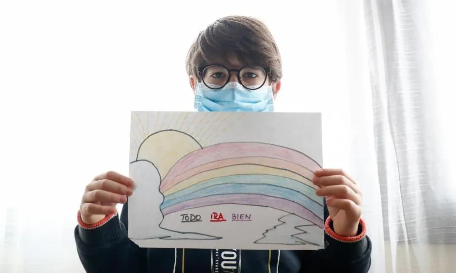 Un niño con mascarilla enseña un dibujo confinamiento por el coronavirus, en Valdemoro, Madrid. Foto de Óscar J.Barroso - EP