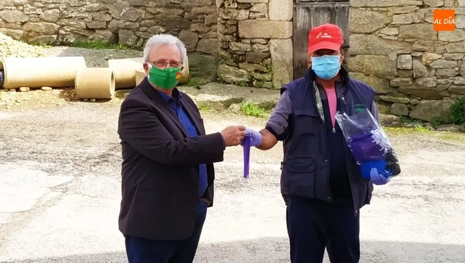 El alcalde, Francisco Antonio Martín Hernández (iz.), le hacía entrega de las mascarillas a un operario municipal para que procediera al reparto