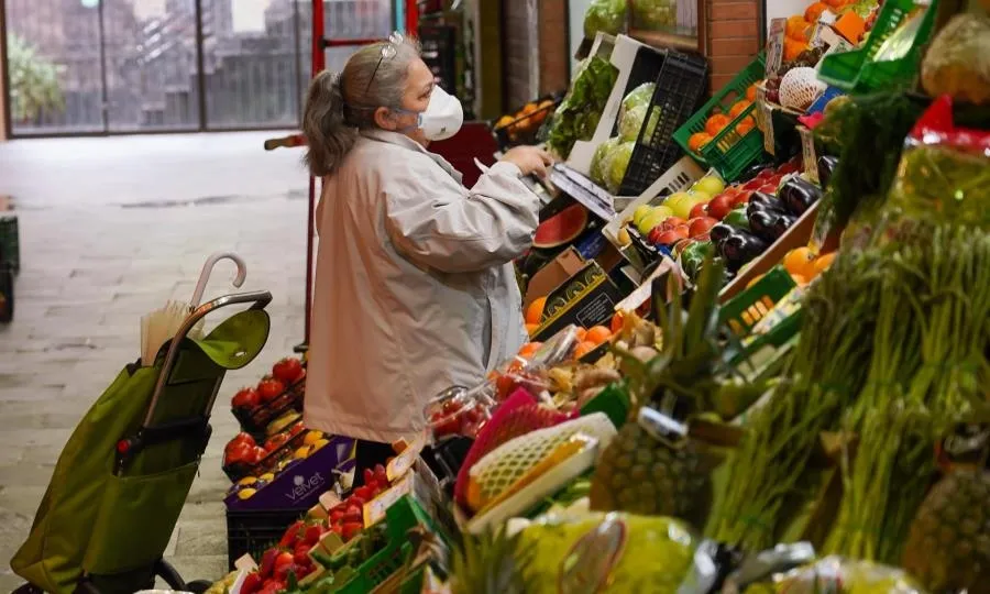 Una señora con mascarilla comprando en el mercado de Triana (Sevilla). Foto de Eduardo Briones - EP