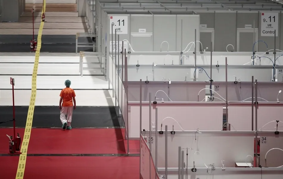 Una sanitaria camina por un pasillo entre mamparas de separación en el interior del hospital de campaña de Ifema. Foto: EP