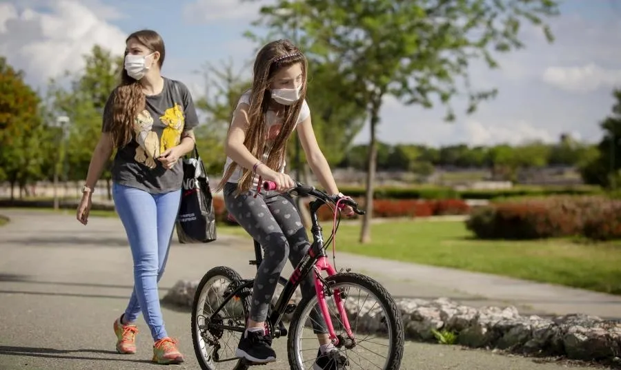 Una mujer con su hija pasean por un parque de Sevilla. Foto de María José López - EP