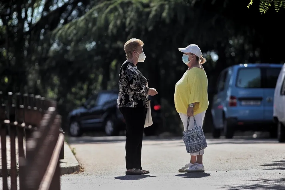 Dos mujeres con mascarilla conversan en la calle. Foto: EP