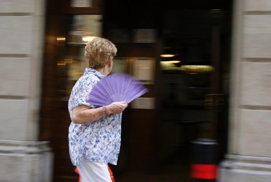 Una mujer se abanica mientras pasea. Foto: EP