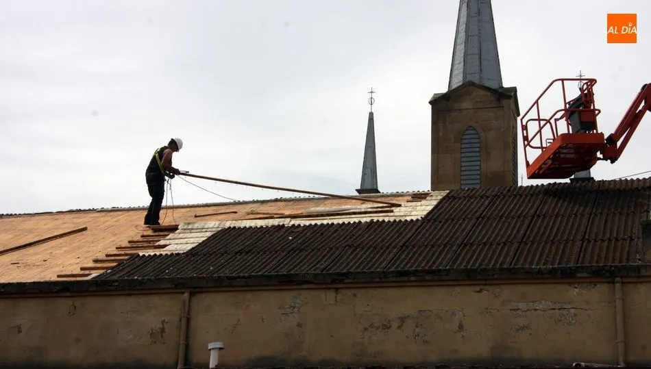 Empleados municipales procedían este martes al desmontaje del onduline del tejado del mercado de abastos / CORRAL