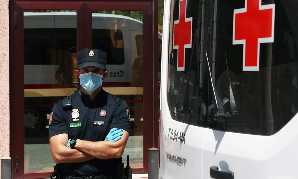 Agentes de la Policía Nacional custodian a los 83 usuarios que están infectados de COVID-19 en una de las sede de Cruz Roja en Málaga | EP