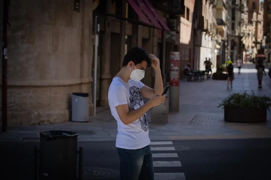 Un joven protegido con mascarilla camina por una calle del centro de Lleida. Foto: EP