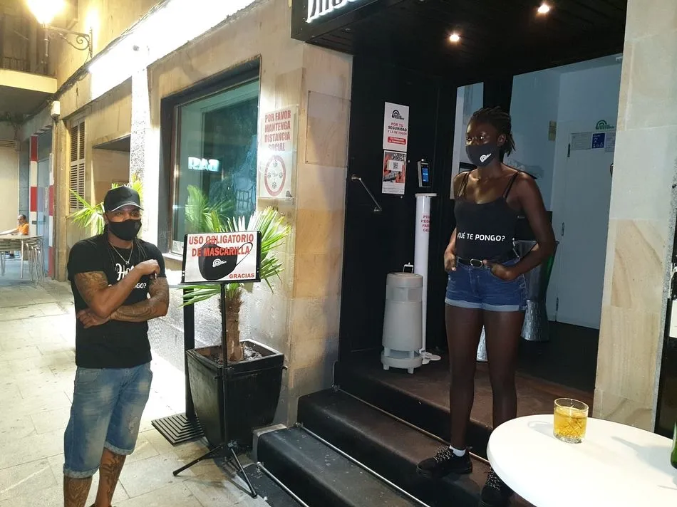 Empleados de ocio nocturno vigilan que los clientes cumplen las normas a la puerta de un local