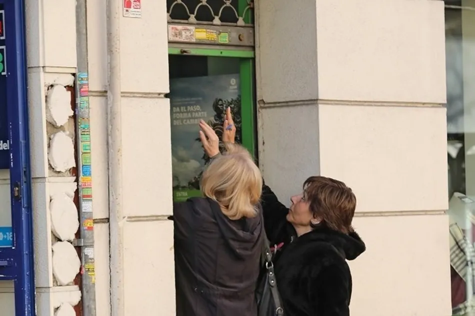 Dos mujeres echan la persiana de una tienda