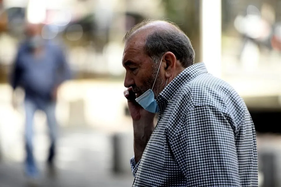 Un hombre con mascarilla habla por teléfono en la calle, en Madrid (España) a 30 de julio de 2020. - Óscar Cañas - Europa Press