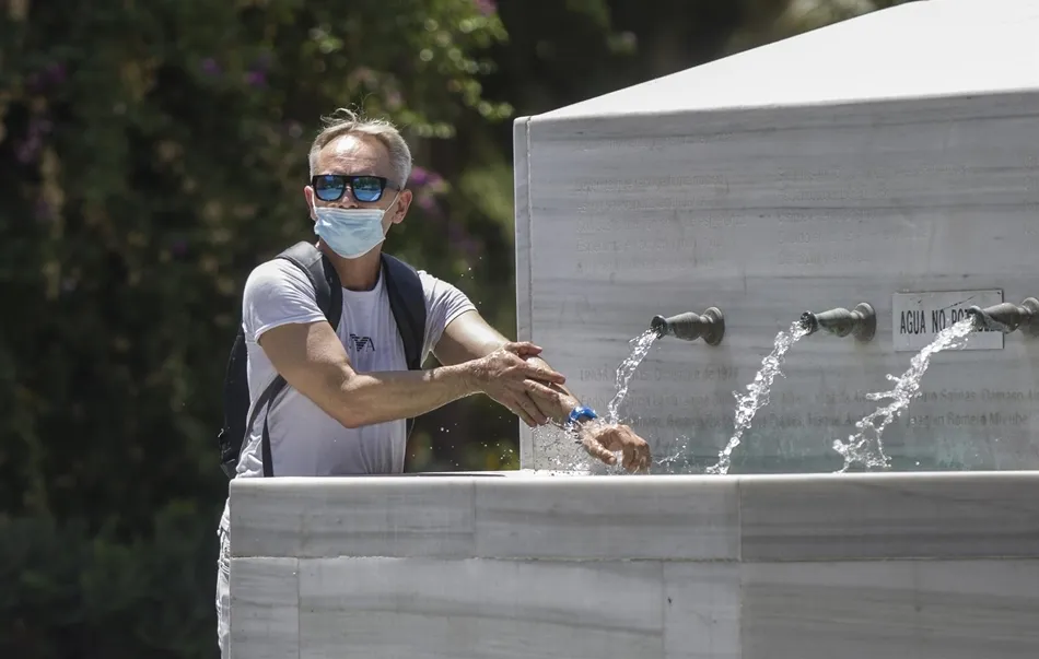 Un hombre se refresca en una fuente. Foto: EP
