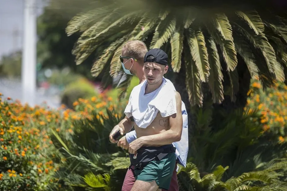 Un hombre con el torso descubierto caminando por la calle por Sevilla - María José López - Europa Press