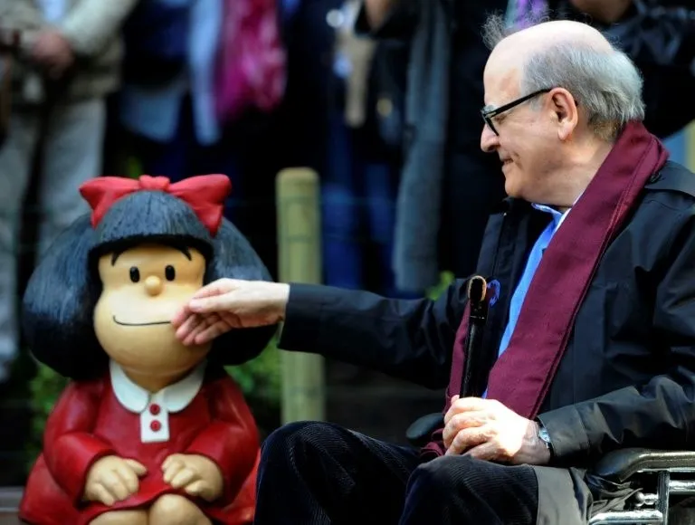 Joaquín Salvador Lavado Tejón Quino junto a una estatua de Mafalda