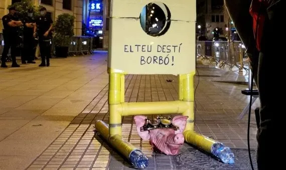 Los CDR colocan una guillotina de cartón con una foto del rey Felipe VI y una cabeza de cerdo en la plaza Urquinaona de Barcelona este sábado. - CDR LES CORTS