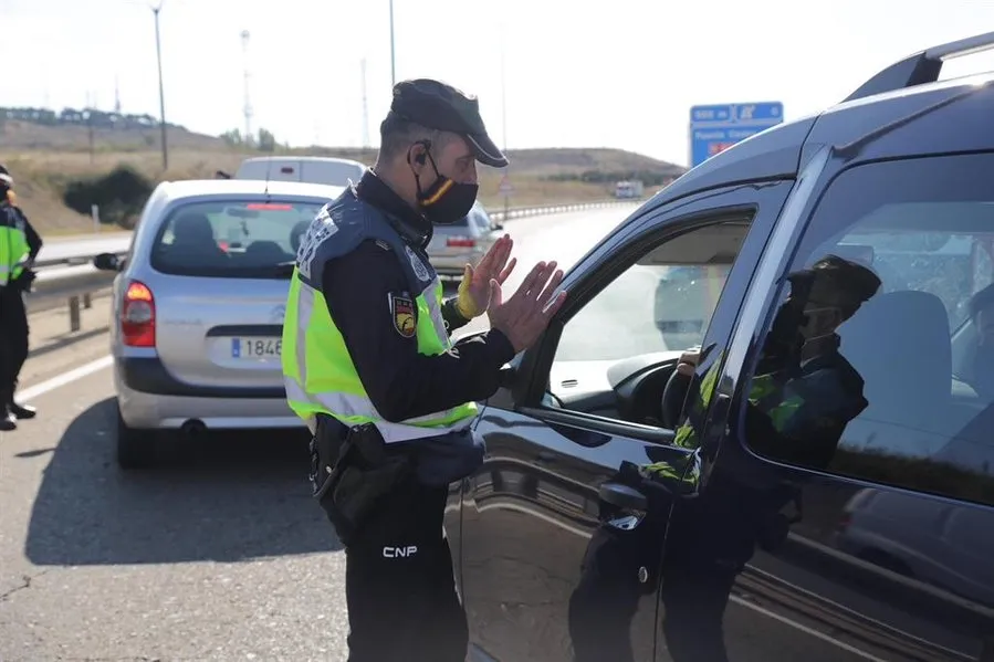 Un agente de la Policía Nacional habla con un conductor en un control policial ante las medidas de restricción de la movilidad en la ciudad de León. Foto de Secundino Pérez - EP