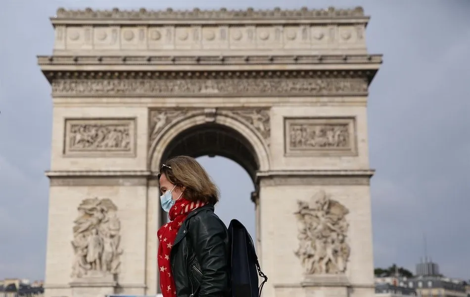 Una mujer con mascarilla ante el Arco del Triunfo de París - GAO JING / XINHUA NEWS / CONTACTOPHOTO