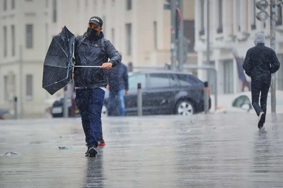 Transeúntes pasean en una jornada marcada por las lluvias y la bajada de temperaturas | ARCHIVO EP