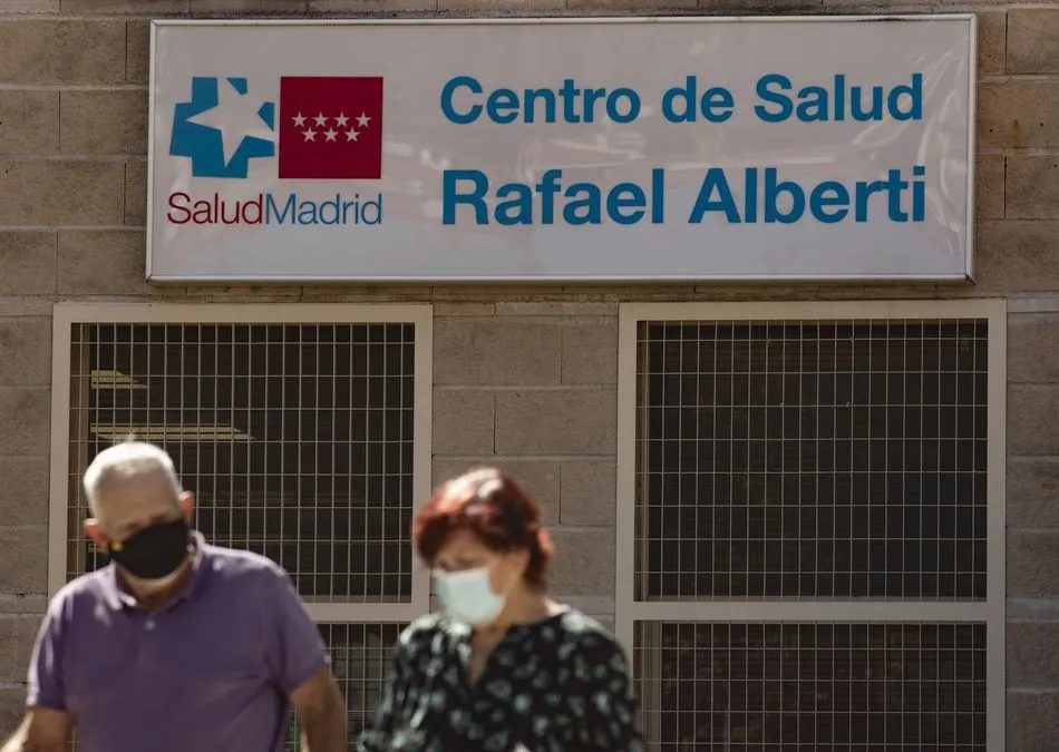 Foto recurso de dos personas caminando al lado del Centro de Salud Rafael Alberto en el distrito de Puente de Vallecas, Madrid | EP