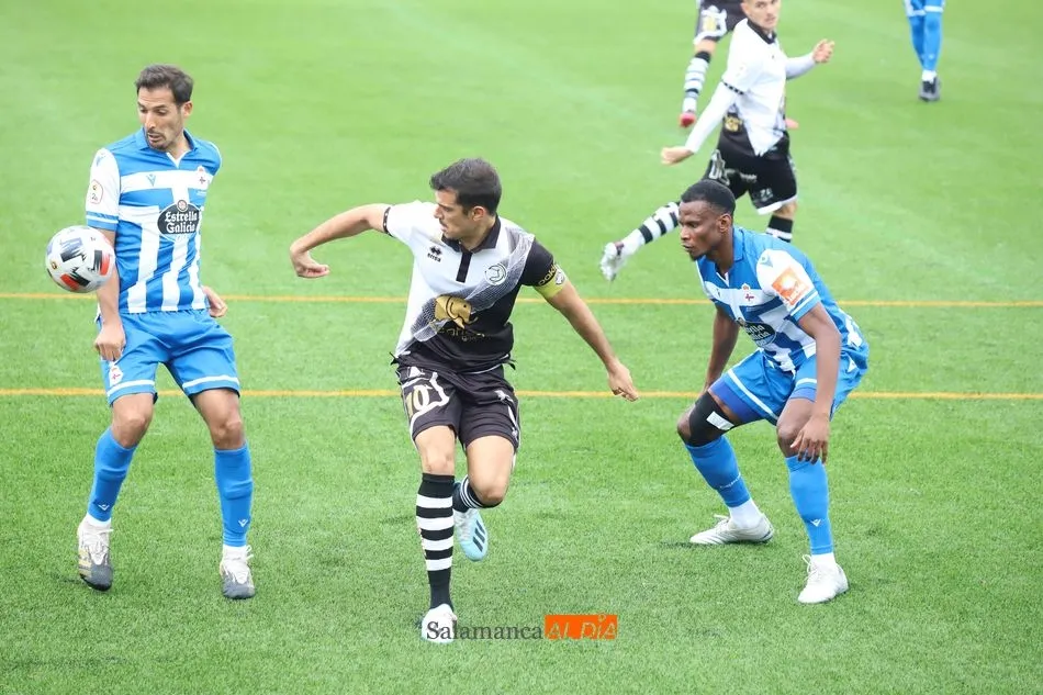 Carlos de la Nava lucha por un balón con dos jugadores del Dépor