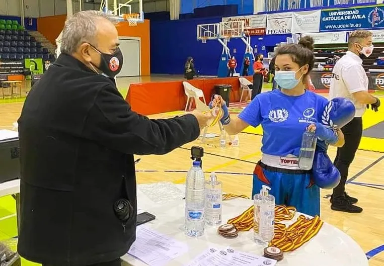 na competidora cumple con las medidas sanitarias mientras recoge su medalla