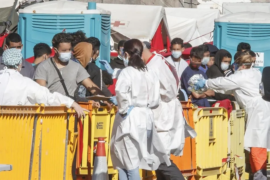Varios inmigrantes son atendidos por personal sanitario en el Muelle de Arguineguín, en Gran Canaria, - Europa Press