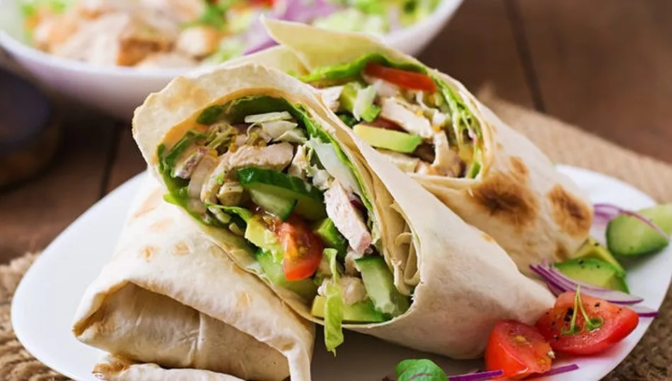 Las fajitas de pollo están aderezadas con  lechuga, crema de yogur de la casa, pimiento y un toque de tex-mex