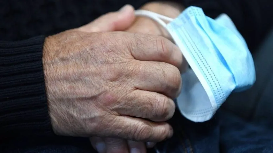 Un hombre mayor sujeta una mascarilla. Foto: EP