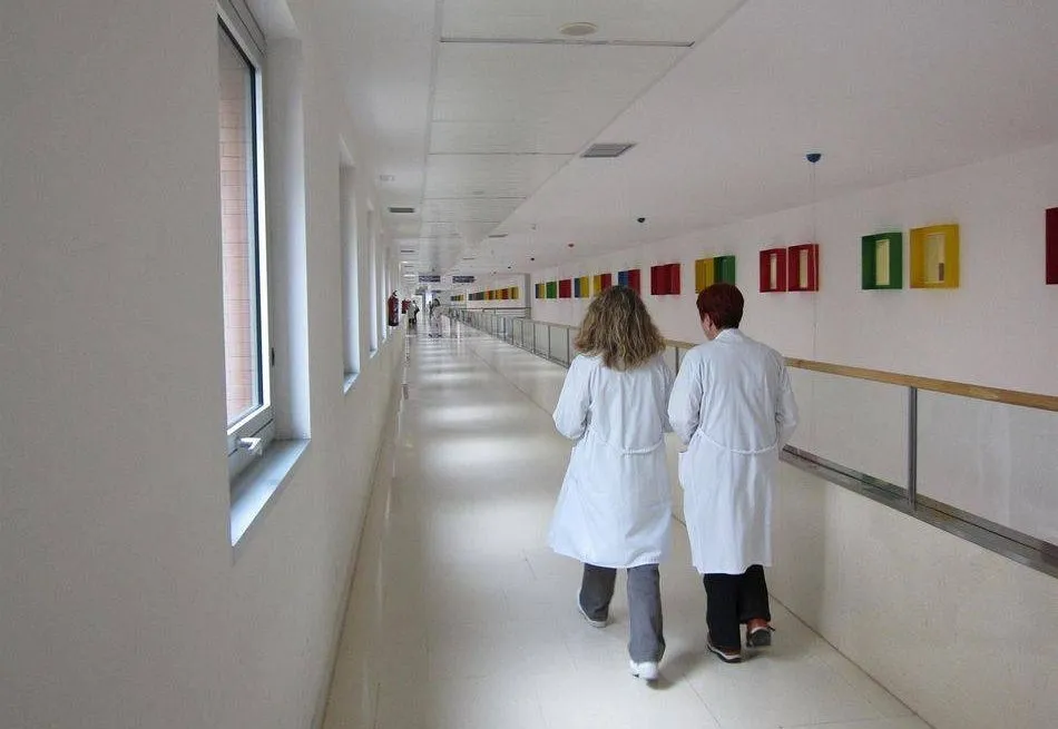 Dos profesionales sanitarias caminan por el pasillo de un centro sanitario
