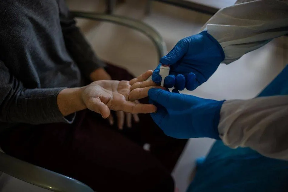 Un profesional sanitario atiende a una mujer en una residencia de mayores