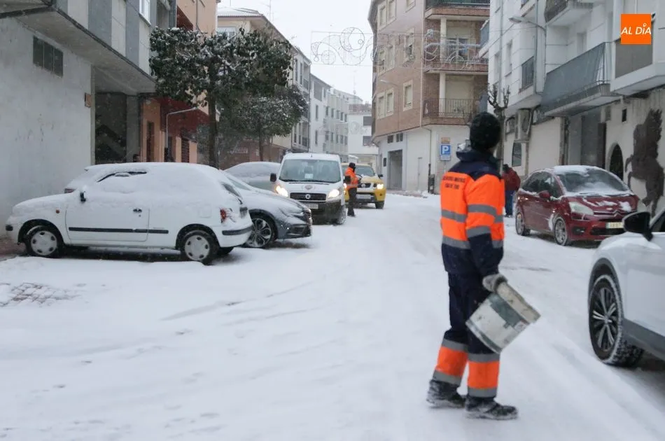 Operarios municipales esparcen sal por la calle Carlos III