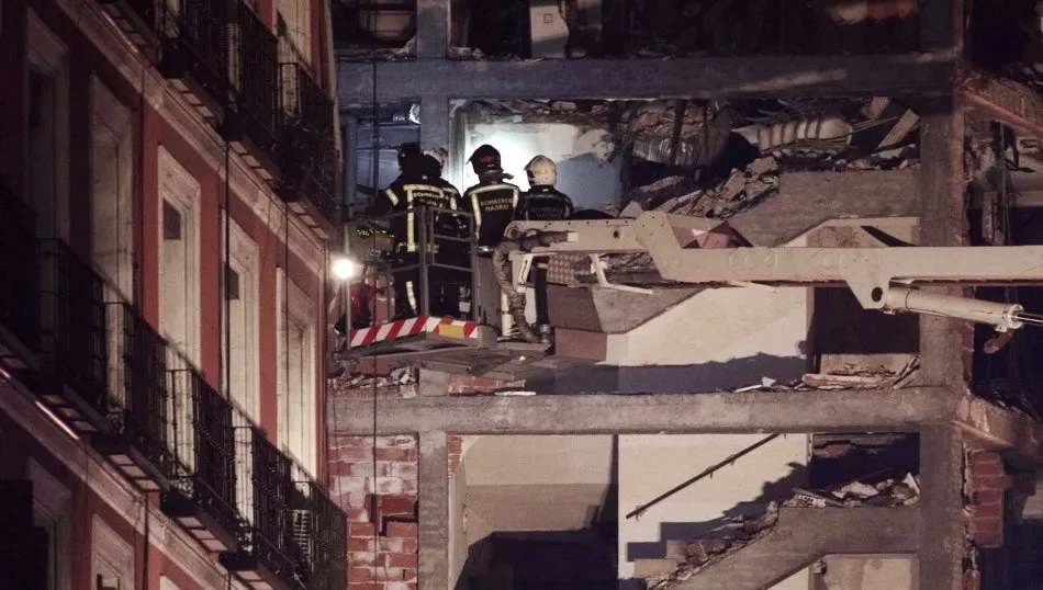 Bomberos con linternas en el inmueble afectado momentos posteriores a una fuerte explosión registrada la calle Toledo que ha hundido varias plantas del edificio, en Madrid. Foto de Eduardo Parra - EP