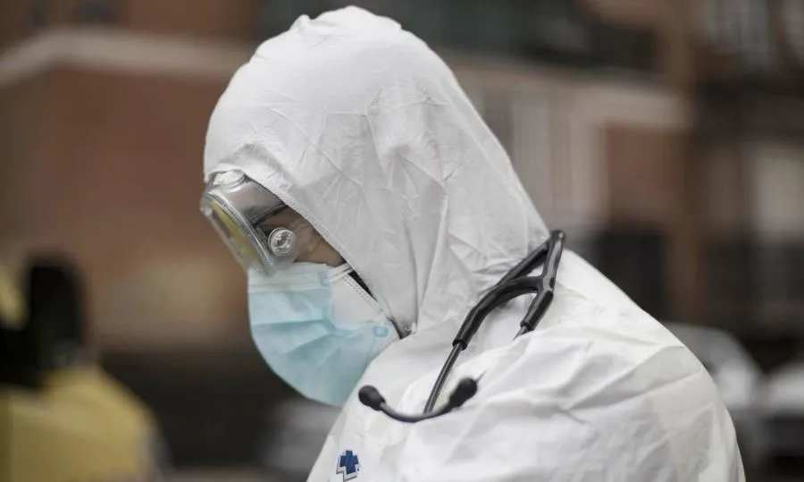Un trabajador de una UVI móvil del SUMMA 112 con el EPI asiste un domicilio durante una jornada de trabajo, en Madrid. Foto Eduardo Parra - EP