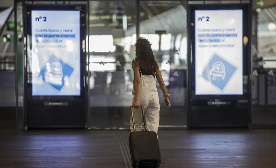 Una mujer con equipaje en una estación de tren. Foto: EP
