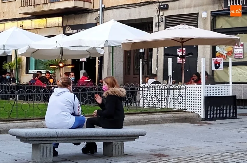 Varias jóvenes conversan sentadas en un banco