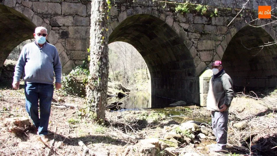 El alcalde de Masueco, Ventura Jiménez, con el concejal, Benjamín Egido, junto al puente de tres ojos / CORRAL