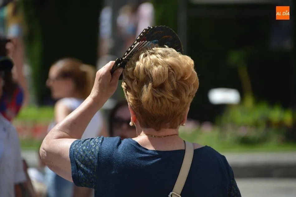 Una mujer se protege del sol con el abanico