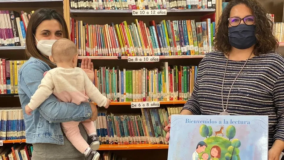 Raquel Bernal (d), respondable dela biblioteca Municipal, hacía entrega a una de las madres los obsequios del Plan LEO