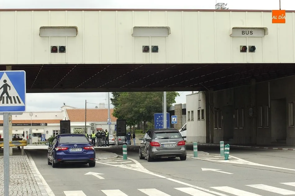 Dos vehículos, un español y otro francés a punto de cruzar la frontera hacia Portugal