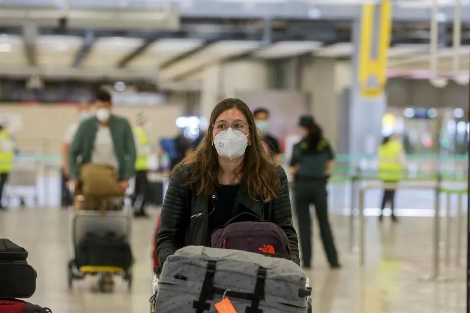 Una joven protegida con mascarilla camina por el Aeropuerto de Madrid-Barajas Adolfo Suárez