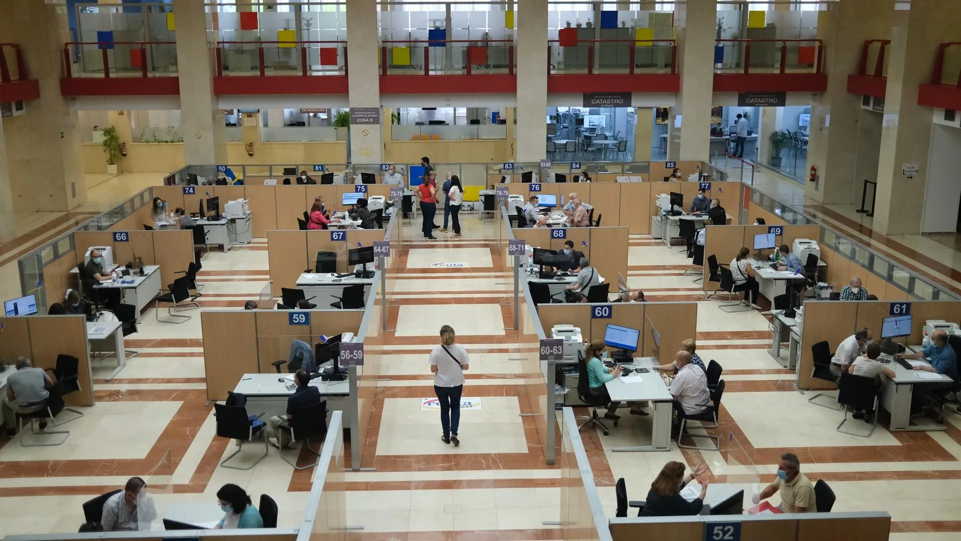 Empleados atienden a contribuyentes de manera presencial desde una oficina de la Agencia Tributaria