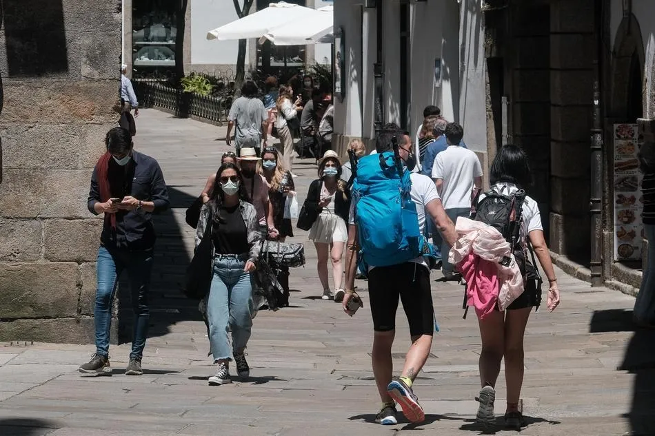 Varias personas caminan por una calle céntrica de Santiago de Compostela. Foto: EP