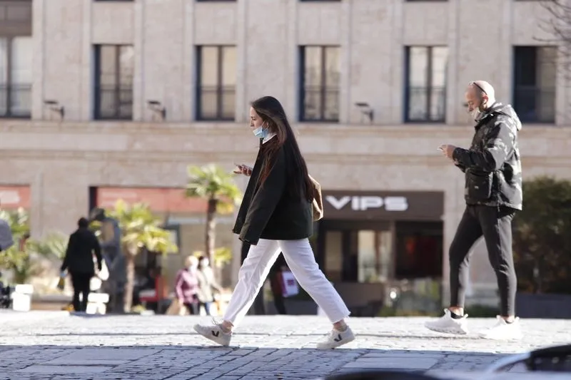 Dos personas paseando por una calle de la ciudad