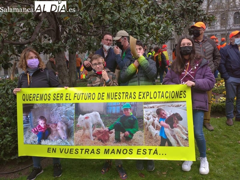 Alba, Mario y Alejandro con la pancarta con fotos de Alejandro y sus hermanos Fran y Rodrigo, quienes desde muy pequeños conocen bien el oficio del campo junto a sus padres, abuelos...