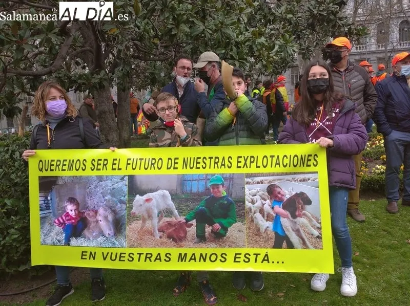 Alba, Mario y Alejandro con la pancarta con fotos de Alejandro y sus hermanos Fran y Rodrigo, quienes desde muy pequeños conocen bien el oficio del campo junto a sus padres, abuelos...