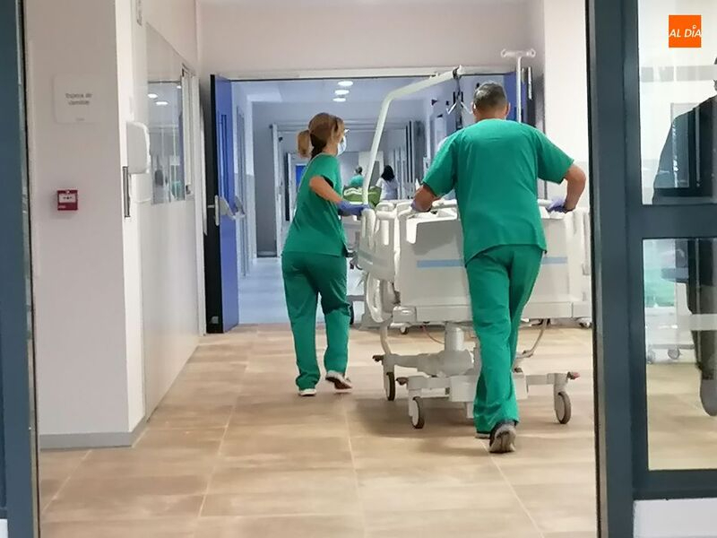 Dos trabajadores del Hospital trasladan a un paciente