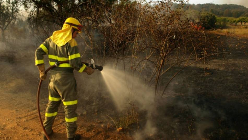 Labores de extinción de un incendio forestal. Foto de archivo